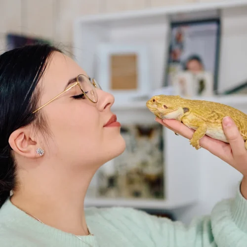 Une femme avec un gecko sur sa main